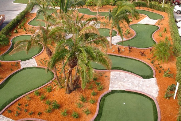 Asheville Aerial view of a mini golf course with synthetic grass and palm trees.